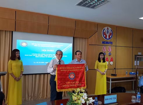Giáo sư Trần Hồng Quân (trái) trao cờ của Hiệp hội cho Giáo sư Trần Trung (ảnh: P.L)