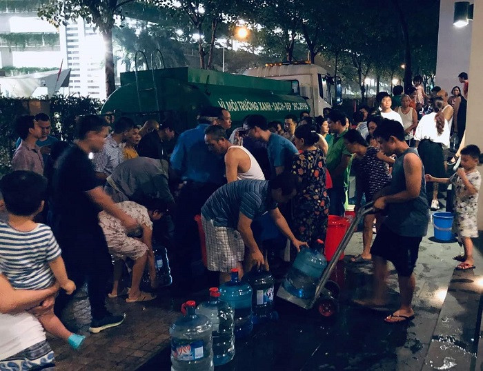 Người dân tranh thủ mang xô, chậu lấy nguồn nước miễn phí (Ảnh:N.D)