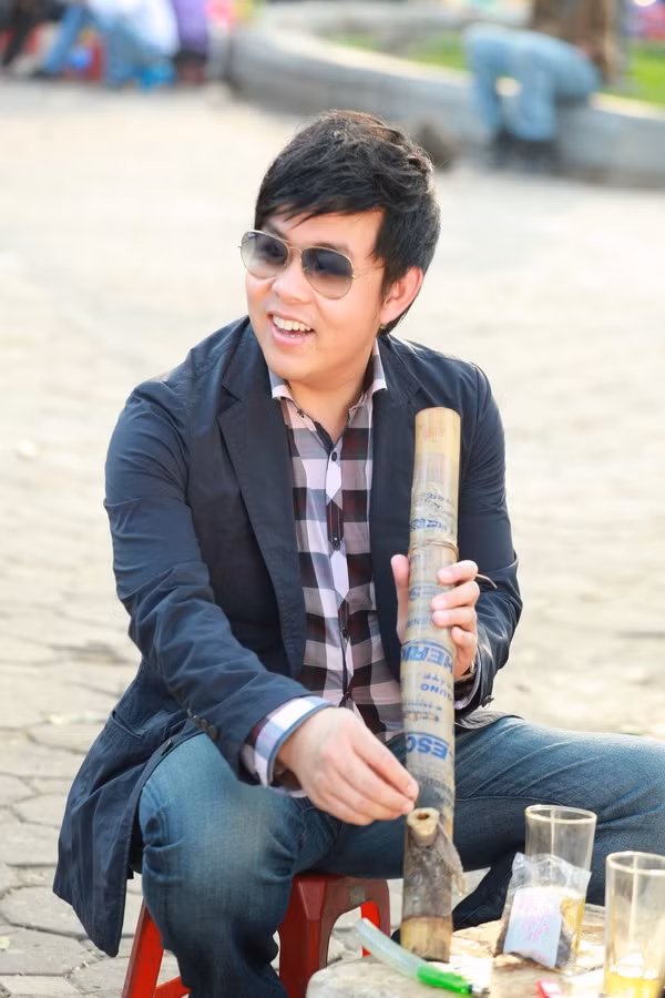Quang Lê thể hiện phong cách dân dã: hút thuốc lào ở Hà Nội. Quang Lê thể hiện phong cách dân dã: hút thuốc lào ở Hà Nội.