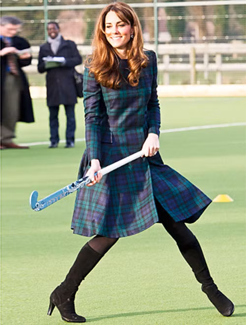 Kate tinh nghịch chơi môn hockey trong bộ áo khoác kẻ caro tinh tế của Alexander McQueen khi đến thăm một ngôi trường. Cô rất thông minh khi chọn nền họa tiết rất giống với đồng phục của học sinh ở đây nhằm tạo nên sự thân thiện