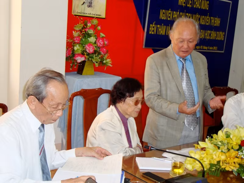 Nguyên Phó Chủ tịch nước Nguyễn Thị Bình (giữa), nguyên Bộ trưởng Bộ Giáo dục & Đào tạo Trần Hồng Quân (trái) đang lắng nghe Giáo sư, Viện sĩ Cao Văn Phường, Hiệu trưởng trường ĐH Bình Dương báo cáo thành tích mà trường đạt được.