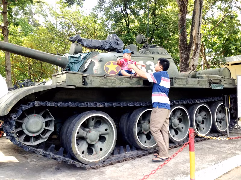 Ông bố trẻ thư thả bế đứa con trai nhỏ lên chiếc xe tăng T54, số hiệu 843 lịch sử. Chiếc xe này đã húc đổ cổng Phủ đầu rồng lúc 10 giờ 45 phút ngày 30/4/1975, chiếc xe tăng thuộc Đại đội 4, Tiểu đoàn 1, Lũ đoàn xe tăng 203, Quân đoàn 2, đã tiến vào húc sập cổng phụ Phủ Đầu Rồng của chính quyền ngụy quyền.