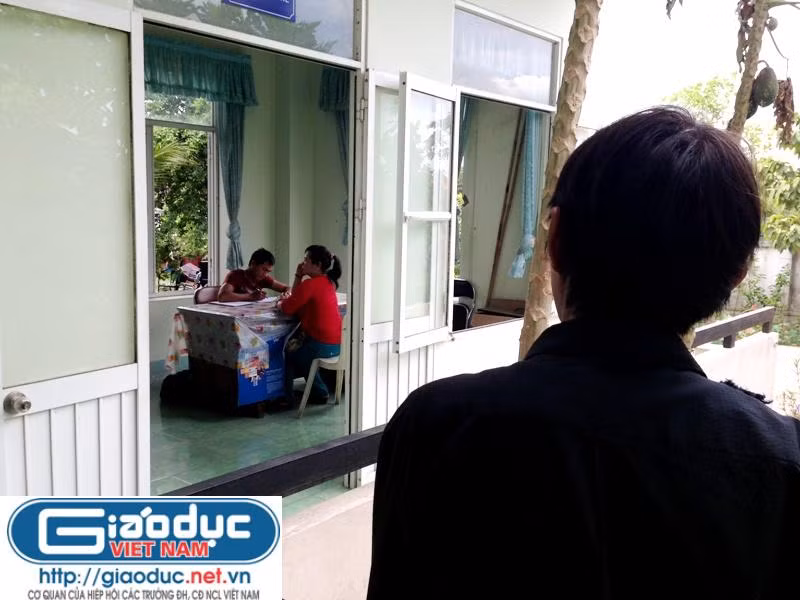 Chồng bà Lê Thị Tuyết, ông Lê Đình Phú đứng từ xa nhìn người vợ có máu "hoạn Thư", bà Lê Thị Tuyết, trước giờ bà bị công an thành phố Thủ Dầu Một, tỉnh Bình Dương tống đạt lệnh bắt giam. Ảnh: Dương Cầm