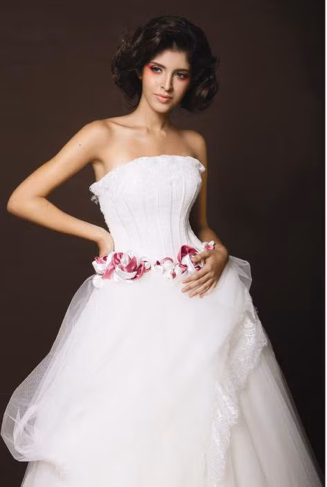 Váy cưới được thiết kế độc đáo. Vòng qua đỏ quanh eo tạo điểm nhấn ấn tượng. Váy cưới được thiết kế độc đáo. Vòng qua đỏ quanh eo tạo điểm nhấn ấn tượng.