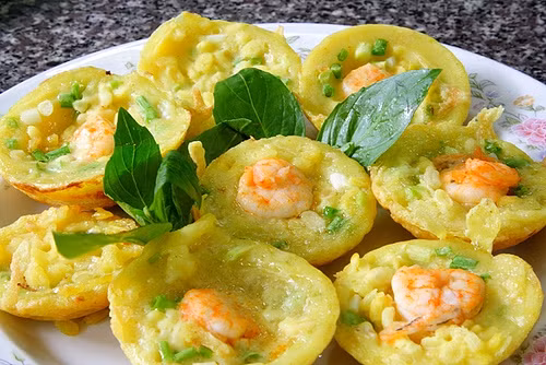 10. Bánh khọt Vũng Tàu Khác với bánh khọt miền Nam và bánh căn miền Trung, bánh khọt Vũng Tàu được chế biến theo kiểu riêng. Nhân bánh gồm có tôm, mực và ruốc xay nhuyễn. Bánh được làm từ bột gạo rất giòn. Bánh khọt Vũng Tàu được ăn kèm với rau sống. Đặc biệt, có đu đủ thái sợi, ngâm giấm ăn kèm nên dù bánh chiên nhiều dầu mỡ, khách vẫn không bị ngán mà càng ăn càng thấy ghiền.