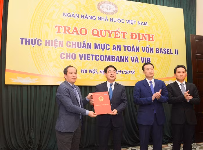 Đại diện Ban Lãnh đạo Ngân hàng nhà nước Việt Nam, ông Đoàn Thái Sơn – Phó Thống đốc (ngoài cùng bên trái) trao quyết định công nhận Vietcombank thực hiện chuẩn mực an toàn vốn Basel II (đại diện Ban Lãnh đạo Vietcombank nhận quyết định: Ông Nghiêm Xuân Thành – Chủ tịch Hội đồng quản trị (thứ 2 từ trái sang; ông Phạm Quang Dũng – Tổng Giám đốc, Trưởng Ban triển khai chương trình Basel II (thứ 2 từ phải sang) và ông Nguyễn Mạnh Hùng - Ủy viên Hội đồng quản trị, Phó Trưởng Ban thường trực Ban triển khai chương trình Basel II Vietcombank (ngoài cùng bên phải). Đại diện Ban Lãnh đạo Ngân hàng nhà nước Việt Nam, ông Đoàn Thái Sơn – Phó Thống đốc (ngoài cùng bên trái) trao quyết định công nhận Vietcombank thực hiện chuẩn mực an toàn vốn Basel II (đại diện Ban Lãnh đạo Vietcombank nhận quyết định: Ông Nghiêm Xuân Thành – Chủ tịch Hội đồng quản trị (thứ 2 từ trái sang; ông Phạm Quang Dũng – Tổng Giám đốc, Trưởng Ban triển khai chương trình Basel II (thứ 2 từ phải sang) và ông Nguyễn Mạnh Hùng - Ủy viên Hội đồng quản trị, Phó Trưởng Ban thường trực Ban triển khai chương trình Basel II Vietcombank (ngoài cùng bên phải).