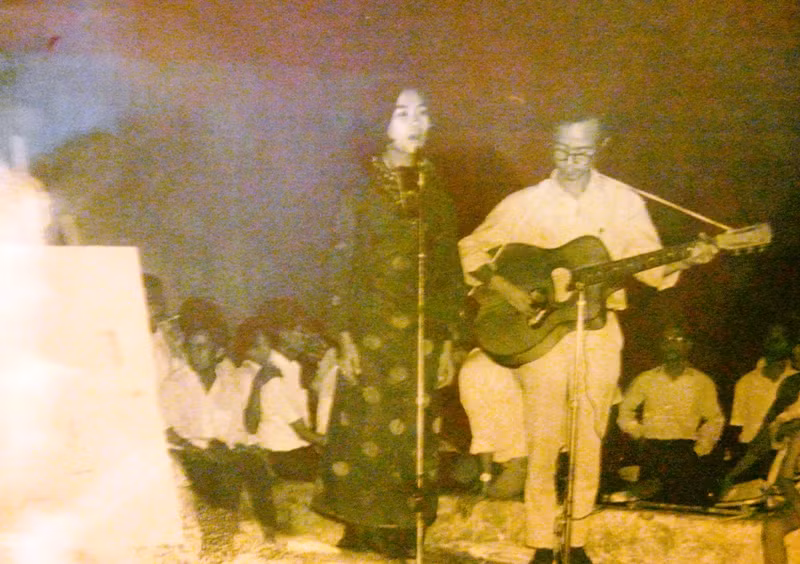 Nhạc sĩ Trịnh Công Sơn đệm guitar cho “Nữ hoàng chân đất” Khánh Ly hát Ru ta ngậm ngùi tại trường đại học Văn Khoa Sài Gòn năm 1967. Nhạc sĩ Trịnh Công Sơn đệm guitar cho “Nữ hoàng chân đất” Khánh Ly hát Ru ta ngậm ngùi tại trường đại học Văn Khoa Sài Gòn năm 1967.