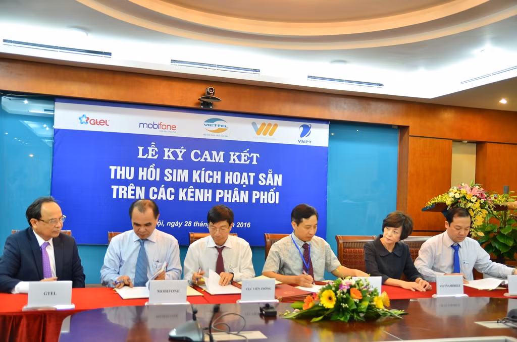 Đại diện 5 doanh nghiệp viễn thông và Cục Viễn thông ký cam kết thu hồi sim kích hoạt sẵn trên các kênh phân phối - Ảnh: H.Lực.