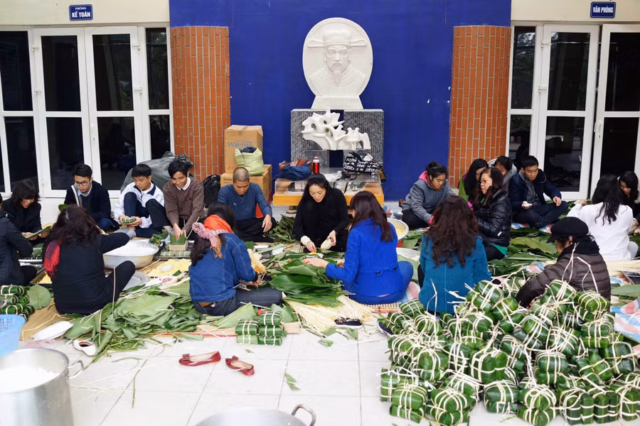 Thầy và trò cùng nhau ngồi gói bánh chưng đón Tết.