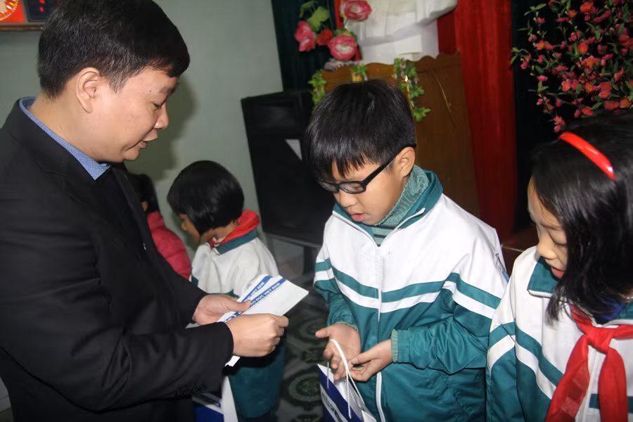 Ông Nguyễn Tiến Bình trao quà cho học sinh nghèo vượt khó của phường Trường Thịnh.