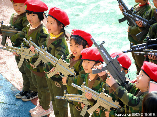 Những cô bé cậu bé tuổi mẫu giáo đã bị người lớn cho ôm súng AK to như thật Những cô bé cậu bé tuổi mẫu giáo đã bị người lớn cho ôm súng AK to như thật