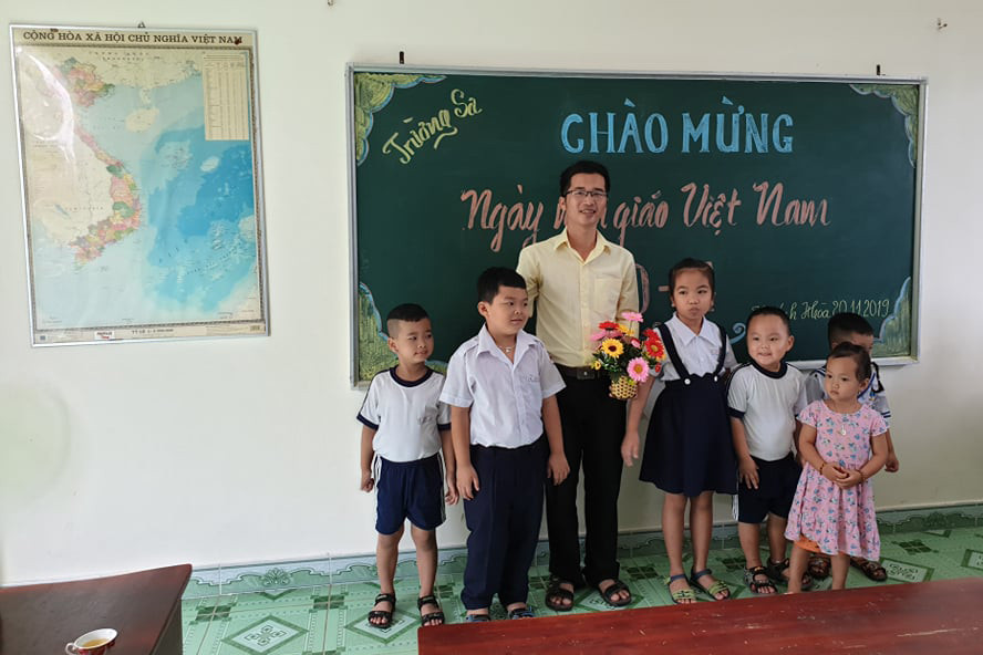 Thầy Bành Hữu Tình cùng các em học sinh. (Ảnh: H.T)