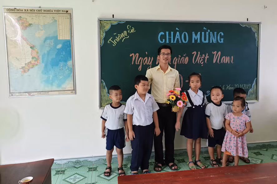 Thầy Bành Hữu Tình cùng các em học sinh. (Ảnh: H.T)
