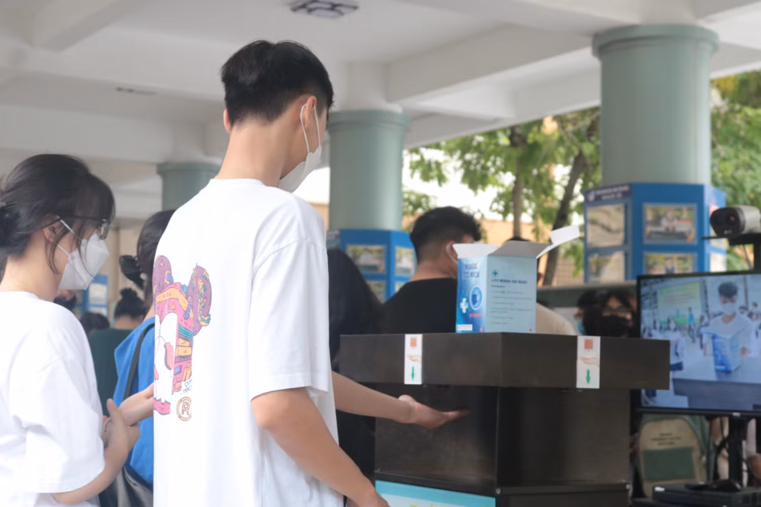 Thí sinh tại điểm trường Trung học cơ sở và Trung học phổ thông Nguyễn Tất Thành tiến hành sát khuẩn tay trước khi vào trường làm thủ tục dự thi. (Ảnh: Doãn Nhàn)