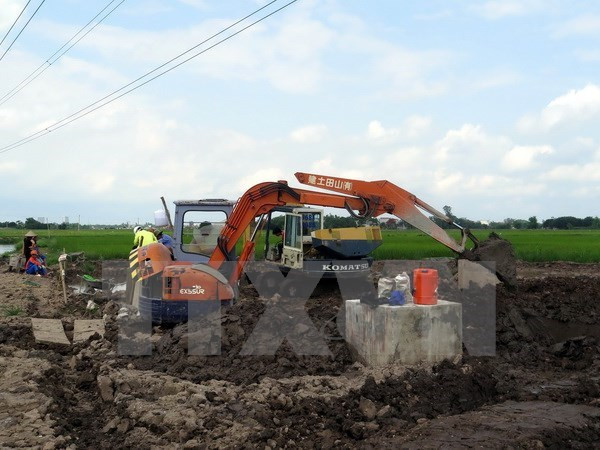 Đơn vị kiểm định chất lượng bêtông tiến hành khoan trụ bêtông cột điện cao thế để lấy mẫu kiểm định chất lượng. (Ảnh: Văn Đạt/TTXVN)