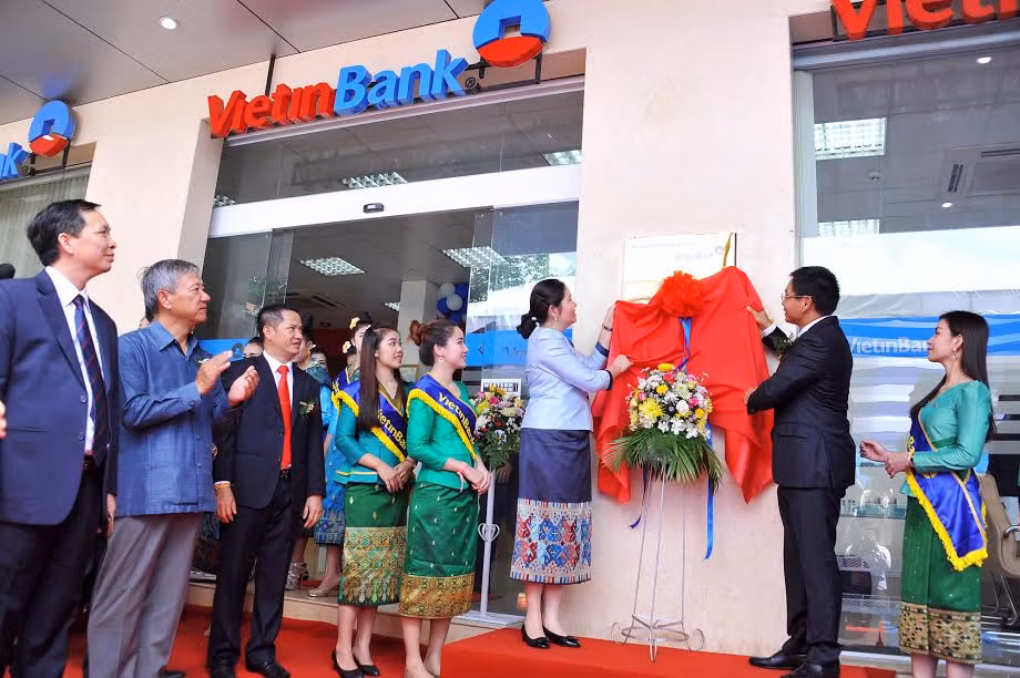 Đại biểu thực hiện nghi thức kéo biển khai trương Chi nhánh Champasak. Đại biểu thực hiện nghi thức kéo biển khai trương Chi nhánh Champasak.