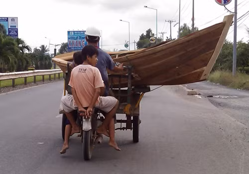 Chở chiếc thuyền trên xe ba gác, chụp tại quốc lộ 51, Bà Rịa - Vũng Tàu. Ảnh: Phú Khoa.