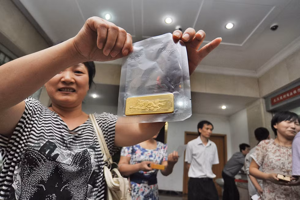 Chị Vạn, một người dân, đồng thời là 1 cổ đông của thôn - tập đoàn Dư Gia Đầu nhận thỏi vàng cổ tức