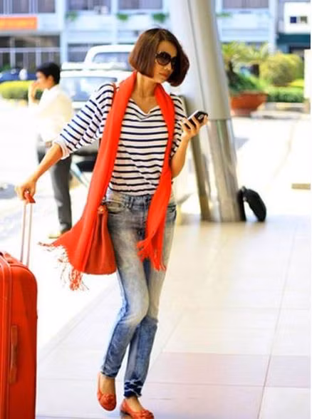 Thanh Hằng luôn ăn mặc rất đẹp và phù hợp với hoàn cảnh. Áo kẻ free size, quần jean đơn giản nhưng điểm nhấn nổi bật của trang phục đó là màu cam của phụ kiện: khăn quàng, giày bệt và cả chiếc va li chị ấy mang theo nữa.
