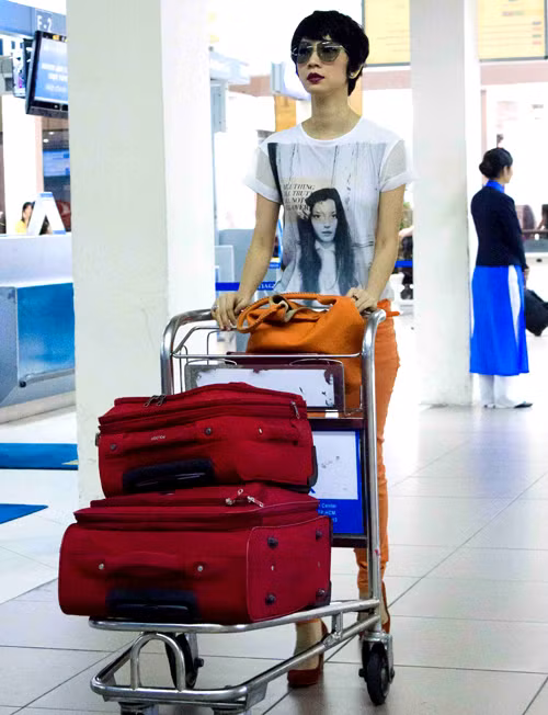 Diện áo thun trắng, quần jeans cam và mang theo những chiếc valy hành lý màu đỏ, nữ giám khảo nổi bật tại sân bay. Diện áo thun trắng, quần jeans cam và mang theo những chiếc valy hành lý màu đỏ, nữ giám khảo nổi bật tại sân bay.