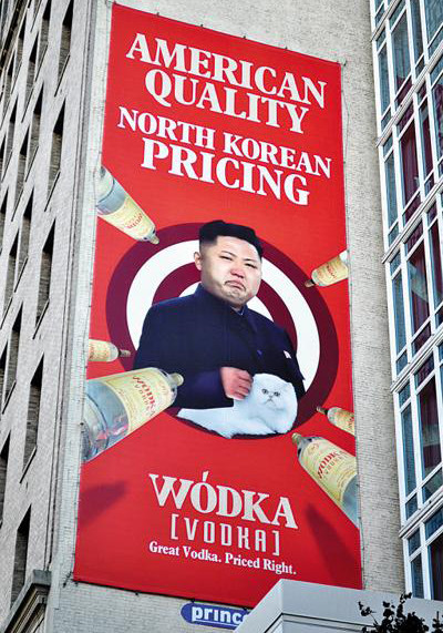 Hình ảnh nhà lãnh đạo Kim Jong-un ôm mèo ở giữa tấm áp phích trong khi những chai vodka như tên lửa chĩa vào Hình ảnh nhà lãnh đạo Kim Jong-un ôm mèo ở giữa tấm áp phích trong khi những chai vodka như tên lửa chĩa vào