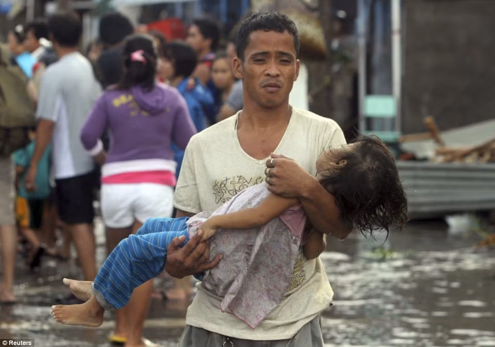 Ông bố Philippines đau khổ ôm thi thể cô con gái đã chết trong bão.