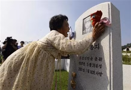 Kim Bu-ok khóc bên mộ cha mình, người đã hy sinh trong cuộc chiến tranh hơn 60 năm trước. Kim Bu-ok khóc bên mộ cha mình, người đã hy sinh trong cuộc chiến tranh hơn 60 năm trước.
