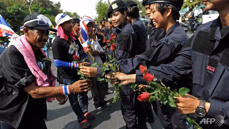 Nụ cười và những đóa hồng đã thay cho đạn cao su, vòi rồng và hơi cay. Người Thái Lan hân hoan chuẩn bị đón mừng sinh nhật Nhà vua, gác lại mọi hiềm khích chính trị.