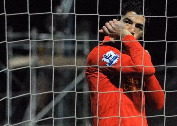 Sau khi 'đánh bóng rổ' ghi bàn, mặc cho sự phản ứng của cầu thủ và khán giả chủ nhà Mansfield, Luis Suarez còn hôn lên tay ăn mừng...