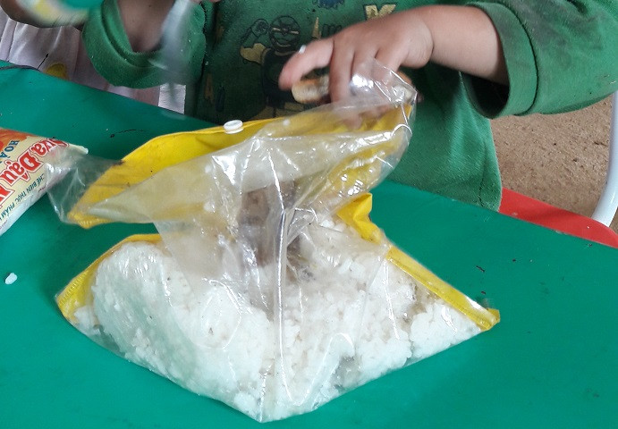 Nhiều em không có cặp lồng con mang cơm đi học mà phải bỏ vào túi ni-lông. Nhiều em không có cặp lồng con mang cơm đi học mà phải bỏ vào túi ni-lông.
