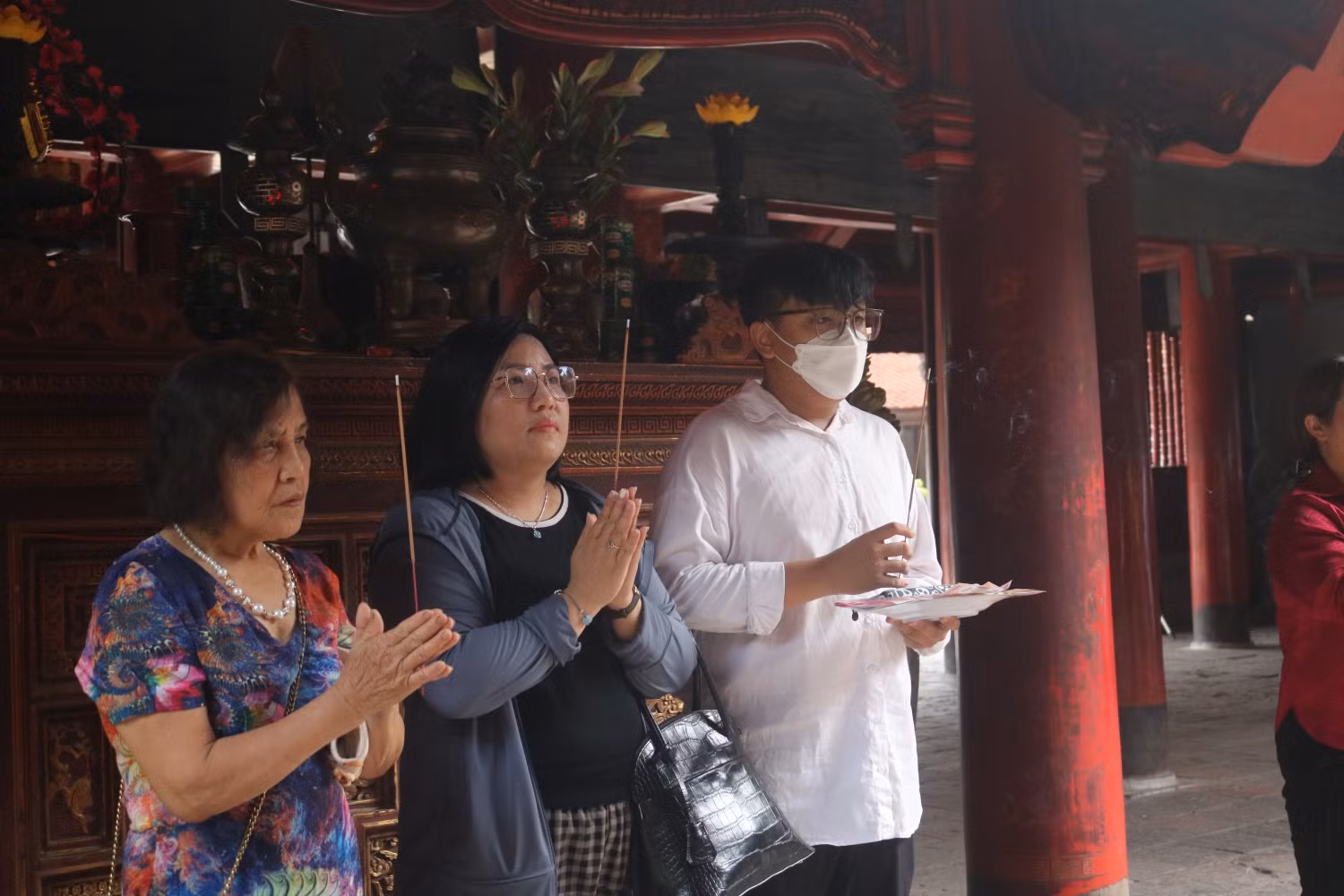 Em Nguyễn Đàm Khánh, Phúc Diễn (đứng ngoài cùng bên phải) chia sẻ: “Em đã hoàn tất việc ôn tập, sẵn sàng bước vào kì thi vào 10 năm nay. Để cổ vũ cũng như động viên tinh thần, bà em hôm nay đã bắt xe từ Phú Thọ xuống Hà Nội cùng gia đình đến thắp hương tại Văn Miếu cầu thi tốt”.