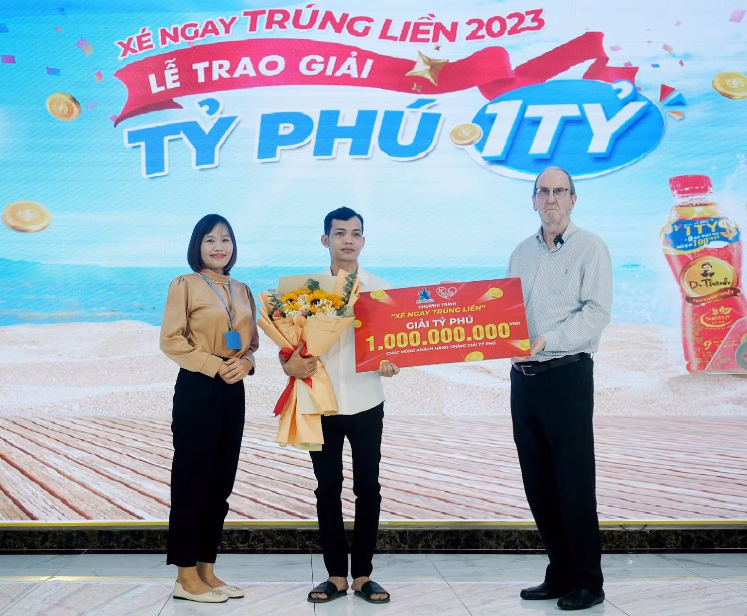 Ông David Charles Riddle – CEO Tập đoàn Tân Hiệp Phát cùng đại diện Sở Công thương Bình Dương chúc mừng anh Nguyễn Hoàng Em trúng giải 1 tỷ đồng khi giải khát với Number 1.