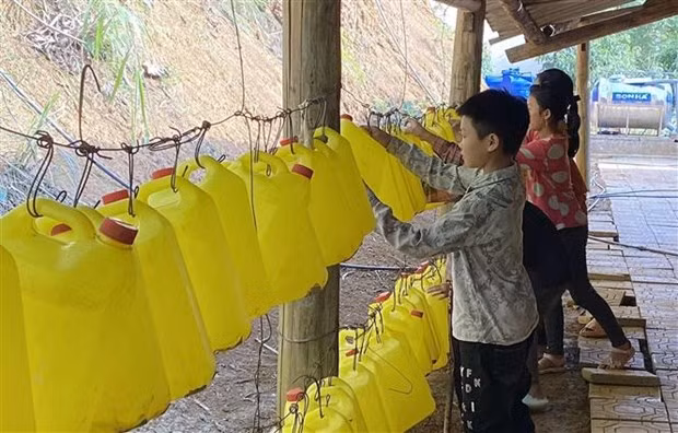 Học sinh Trường phổ thông dân tộc bán trú tiểu học Tả Gia Khâu, huyện Mường Khương dùng can nhựa lấy nước sử dụng sinh hoạt hàng ngày. (Ảnh: Quốc Khánh/TTXVN)