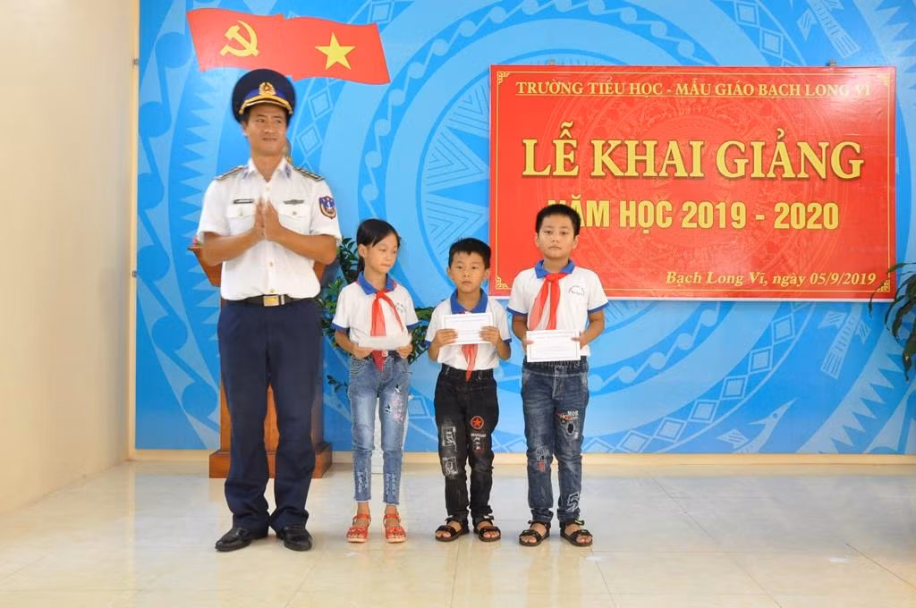 Đại diện Hải đoàn 11 - Vùng Cảnh sát biển 1 tặng quà các em học sinh của huyện đảo Bạch Long Vĩ