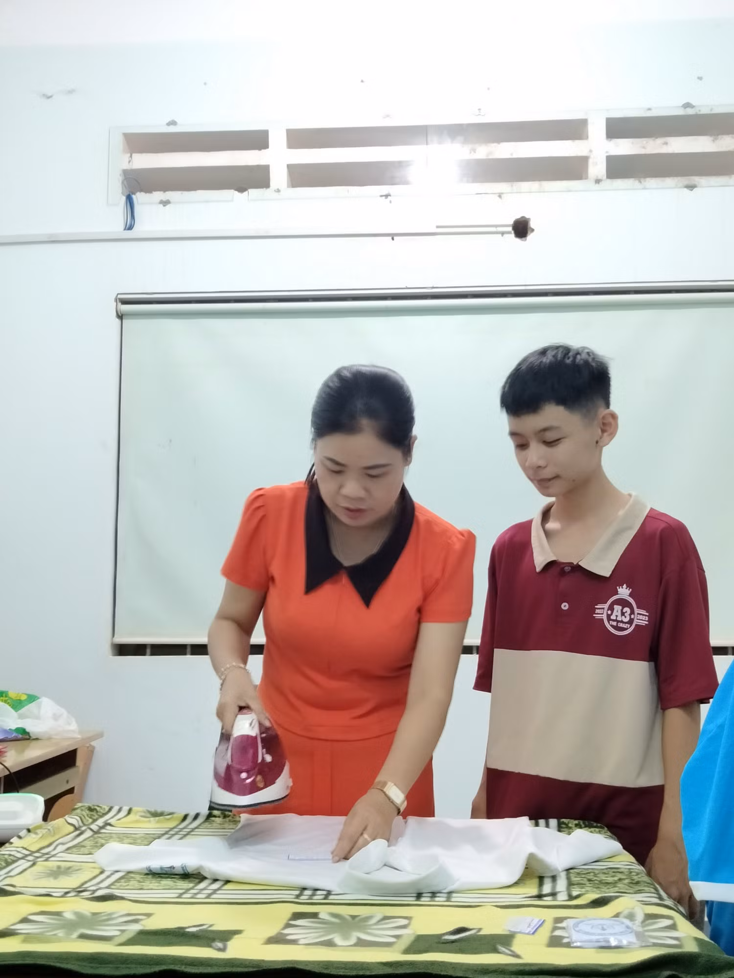 Cô Hoàng Thị Bảy đang giúp học sinh là ủi áo. Ảnh nhân vật cung cấp. Cô Hoàng Thị Bảy đang giúp học sinh là ủi áo. Ảnh nhân vật cung cấp.