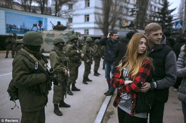 Người dân Ukraina trước một hàng rào tay súng tại Crimea.