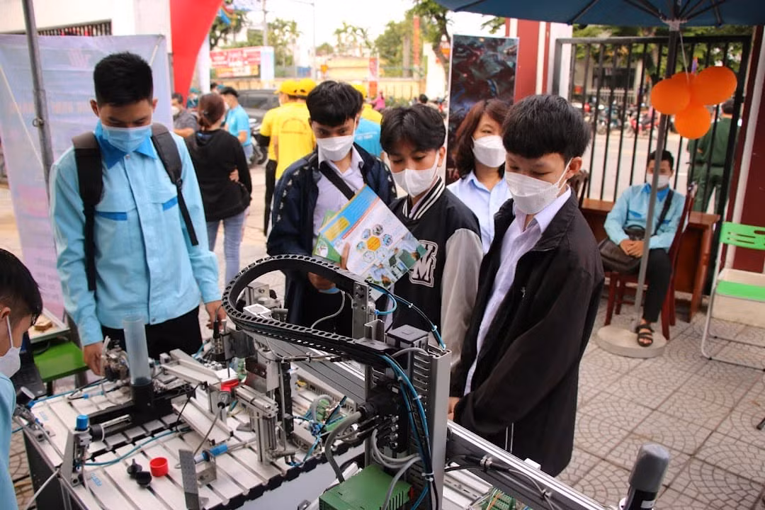 Học sinh trải nghiệm thực tế trên mô hình sản xuất bóng đèn tự động. Hình ảnh tại gian hàng của Trường Cao đẳng nghề Đà Nẵng trong Ngày hội việc làm và tuyển sinh giáo dục nghề nghiệp tại Quận Cẩm Lệ năm 2022. Ảnh: Fanpage nhà trường
