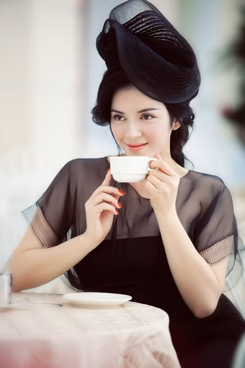 Chiếc mũ đen có chất liệu dày dặn, tạo khối hình hoa cách điệu hòa quyện cùng chiếc đầm đen có điểm nhấn phần trên bằng cách đổi chất liệu vải sheer bên trên và lụa bên dưới tạo ra những khối màu đen đồng nhất mà vẫn khác biệt về sắc độ. Chiếc mũ đen có chất liệu dày dặn, tạo khối hình hoa cách điệu hòa quyện cùng chiếc đầm đen có điểm nhấn phần trên bằng cách đổi chất liệu vải sheer bên trên và lụa bên dưới tạo ra những khối màu đen đồng nhất mà vẫn khác biệt về sắc độ.