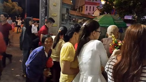 Một bà cụ đang xin tiền của khách vãn cảnh chùa Vĩnh Nghiêm sáng sớm mùng 1 tết (Ảnh: T.P)
