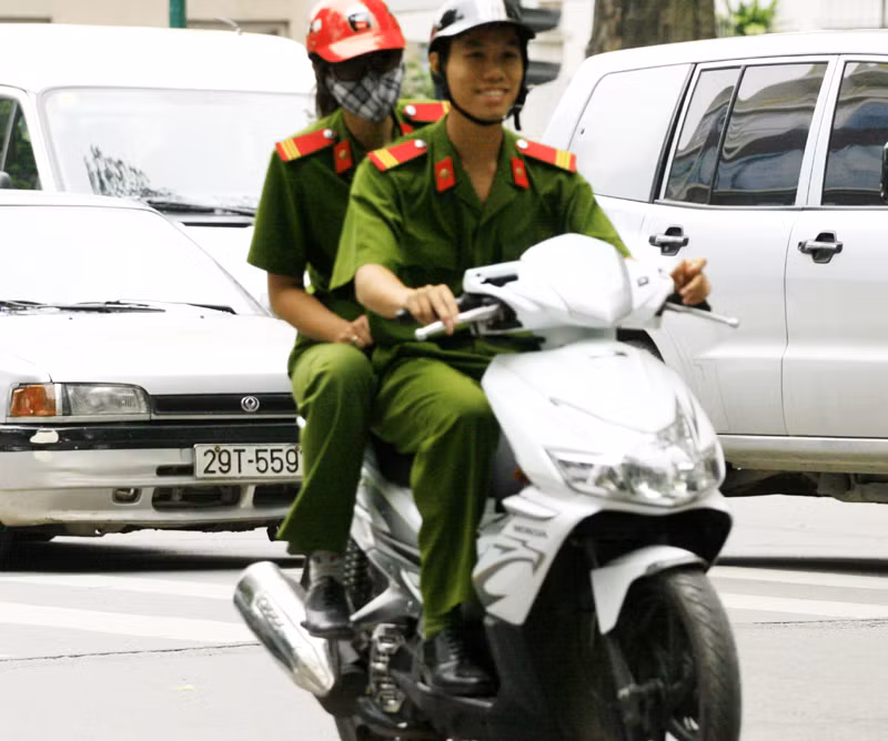 Chiến sĩ công an này thoải mái đèo một đồng nghiệp nữ khác