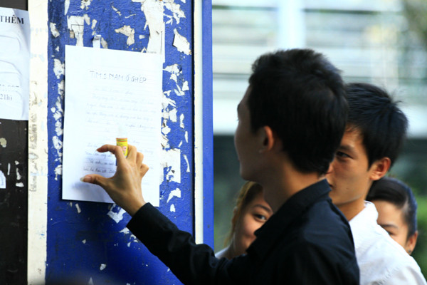 Hồn nhiên dán tờ rơi lên bốt điện thoại thẻ