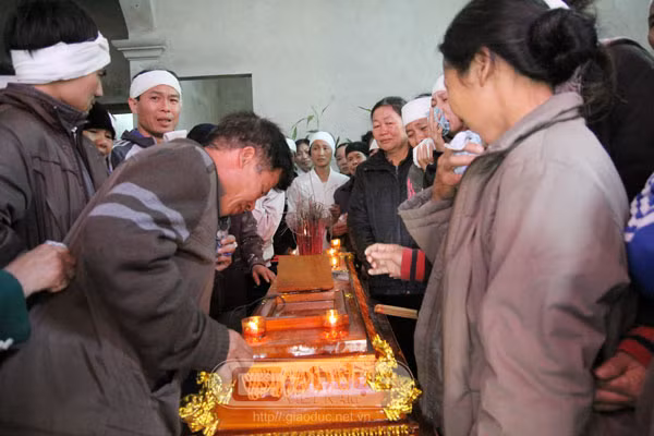Ông Nguyễn Công Thành, bố chị Quỳnh (người cúi) nhìn mặt con lần cuối.