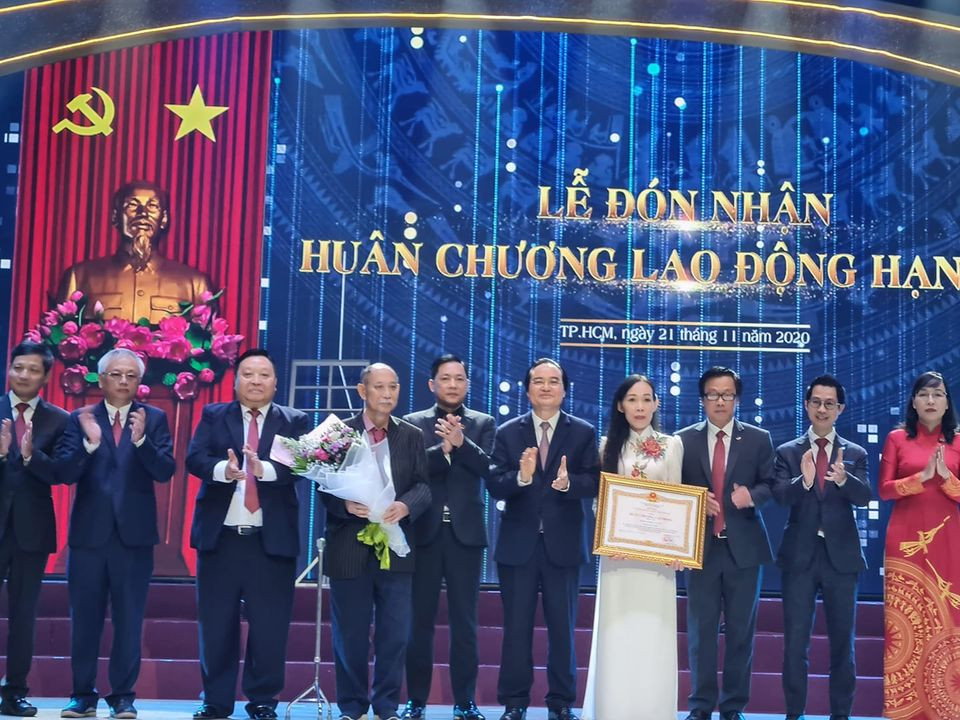 Bộ trưởng Phùng Xuân Nhạ (thứ 5, phải sang) trao Huân chương Lao động Hạng Ba cho trường (ảnh: P.L)