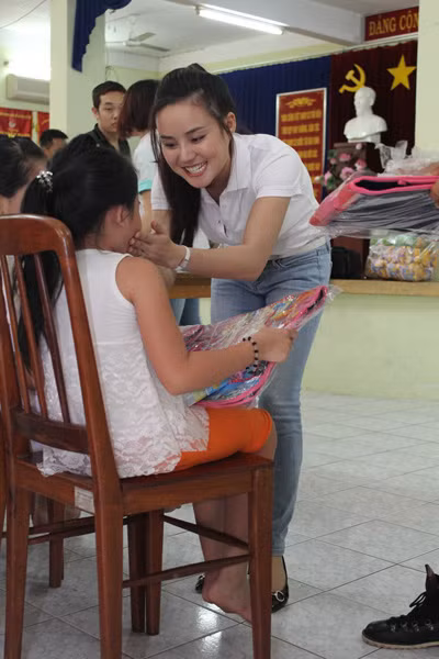 Vy Oanh tự tay bê vác cặp sách từ ngoài vào trong và trao cho từng em một cách ân cần.(Theo Ngôi Sao) Vy Oanh tự tay bê vác cặp sách từ ngoài vào trong và trao cho từng em một cách ân cần.(Theo Ngôi Sao)