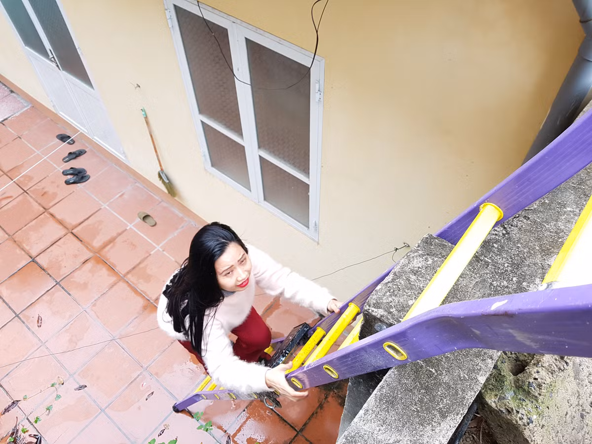 Hai mẹ con cô giáo Quyến mỗi ngày phải trèo thang vài lần để ra ngoài mua sắm vật dụng sinh hoạt (Ảnh: Lã Tiến)