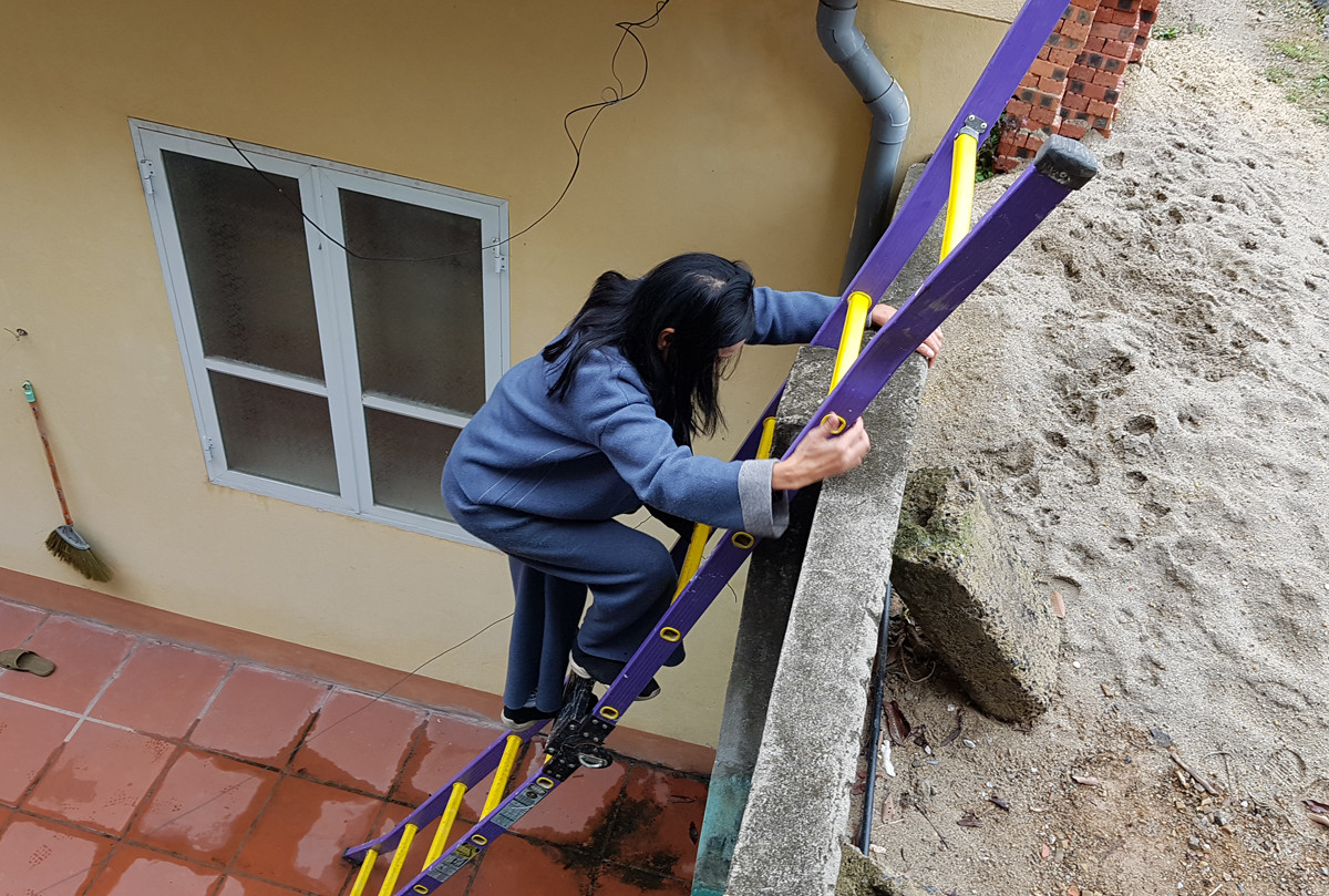 Hơn nửa tháng qua, cô giáo Quyến phải trèo thang để ra ngoài (Ảnh: Lã Tiến)