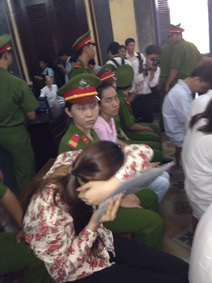 Bị cáo Thiên Kim lẩn tránh ống kính phóng viên. Ảnh: Dương Cầm