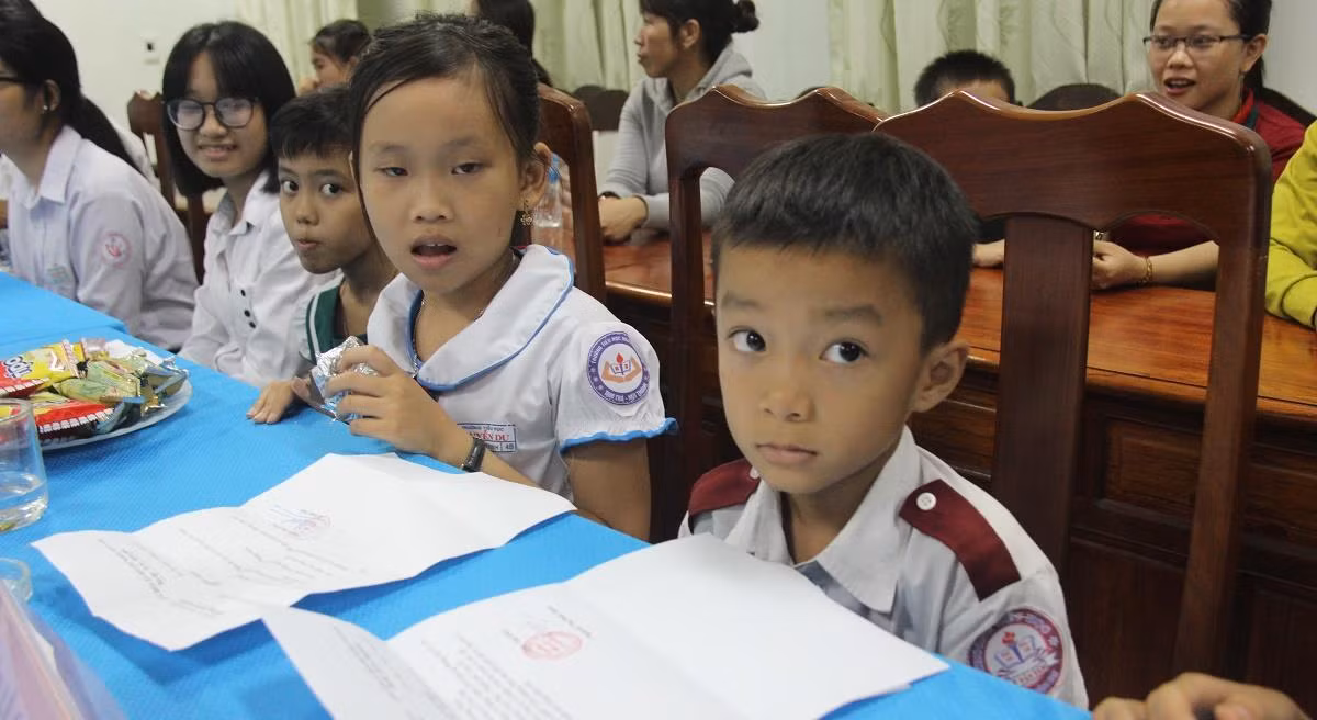 Niềm vui của những cô, cậu học trò nhỏ khi được nhận học bổng. Ảnh: AN
