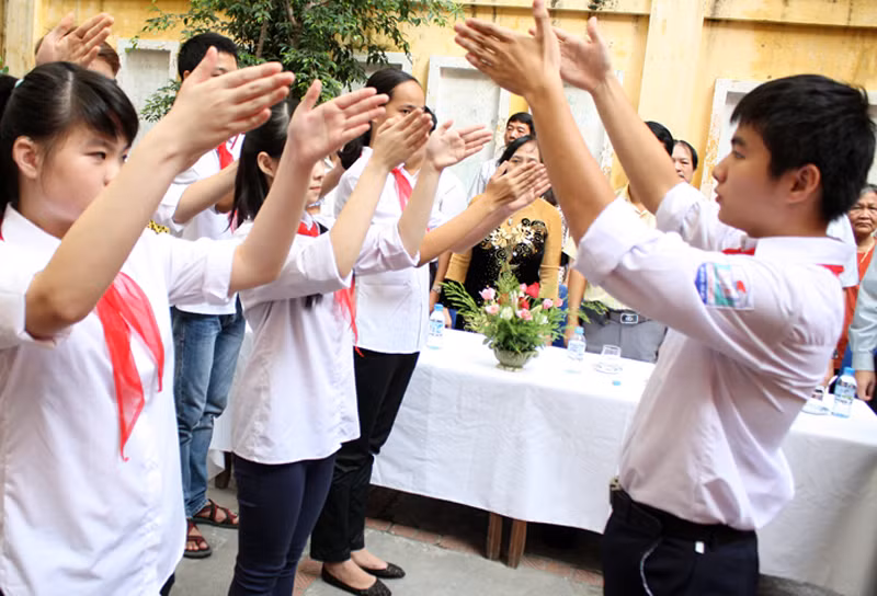 Các em học sinh khiếm thính trường PTCS Xã Đàn hát Quốc ca bằng tay. Ảnh: Giàng A Cối