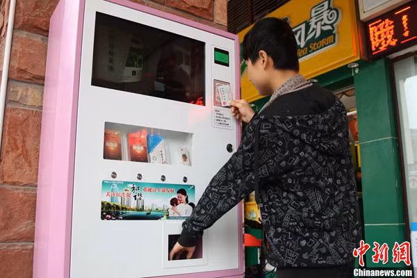 Một sinh viên đại học Trùng Khánh quẹt chứng minh thư nhân dân để lấy bao cao su miễn phí